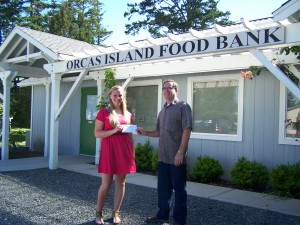 Mykal Keyes hands $300 to Larry Shaw, Food Bank Board President.