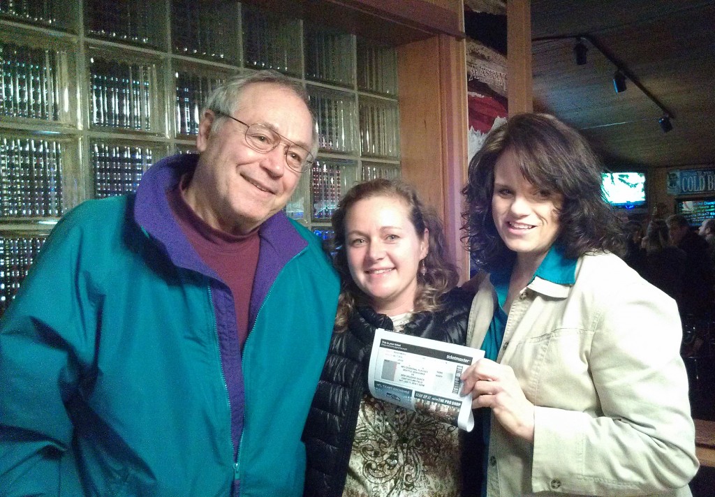 Kaleidiscope Board President Rick Markov and Director Amber Paulsen present high-bidder Wendy Shinstine with her Seahawks playoff tickets last week. Photo: Margie Doyle