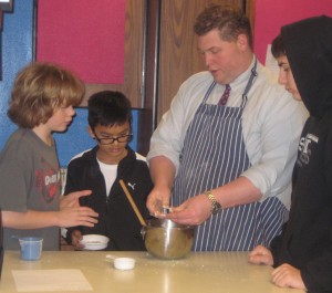 Culinary arts students Kellen Maier, Sirie O’Toole and Garret Ballanger get  instruction on the proper texture for tortilla dough 