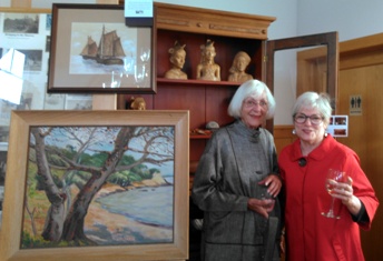 Millie Vaccarella and Susan Mustard kibbitz over island paintings and the Gibson rolltop desk