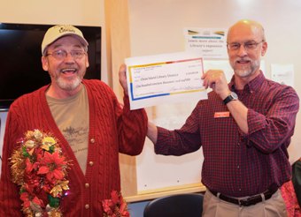 Tim Lunde presents Phil Heikkinen a check for $119,000 from the Friends of the LIbrary