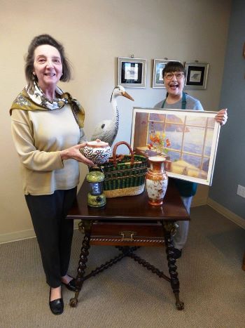 Millie Vetterlein and Gael Shipstad hold some of the treasures from Granny's Attic. The sale is this Saturday from 10 a.m. to 3 p.m.