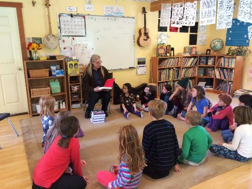 Leslie Seaman reads from freshly-donated dictionaries to Salmonberry students