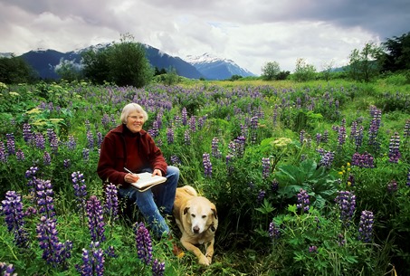 Rie Muñoz sits with her dog Muncie in a field of lupine near her home.  (Mark Kelley photo, 2008)