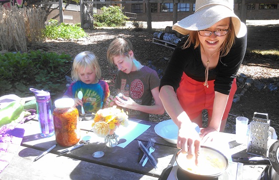 Colleen Stewart, Orcas school gardenkeeper, works with students and visitors to make calendula salve