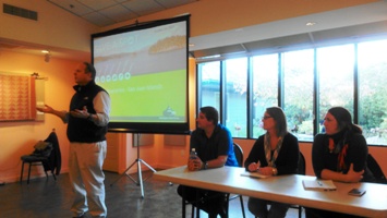 Rick Hughes, at left, greets those who attended the Orcas Ferry Reservations meeting on Oct. 15. Seated at the table, left to right are Kristina