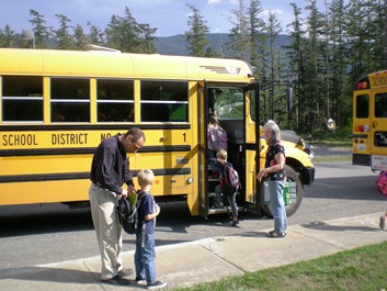 Kindergarten teachers help students board the school bus