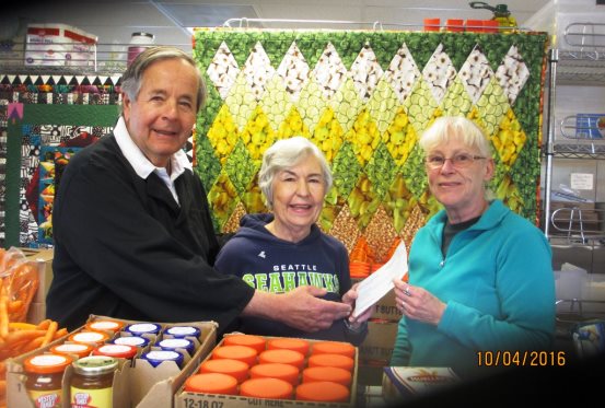 Tom Murdock and Judy Schliebus present a check benefiting the Food Bank to Jeannie Doty 