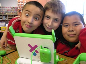 3 kids in the XO club working wiith the sturdy portable computer 