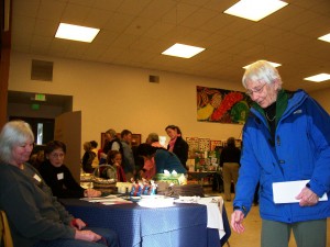 Rachel Adams greets a canine friend with Debra Yeamans at the Animal Protection Society's table at the Volunteer Friends. 