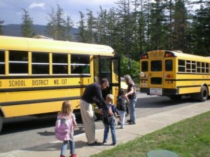 Teachers Mathew Chasanoff and Pam Jenkins escort kids to school buses at the front of the Orcas High School. State transportation officials advised that bus loading in front of the elementary school was unsafe, and teachers now walk with their students to their buses.
