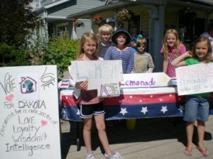 Hannah Gilliland, and Audrey Creevey, in the foreground, offering lemonade in exchange for votes for Dakota. They are assisted in the background by James Poulson, Margo Gilliland, Jack Poulson and Abby Weeks.