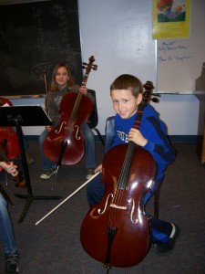 Back left, Emma Heikkinen, and Liam Tidrington (foreground) prepare their cellos for performing this evening.