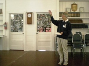 At the Deer Harbor Community Club, Sue Foulk explains Deer Harbor history to tourists from the Senior Center