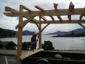 Zackarya Leck chisels the finishing touches on a pergola made from salvaged lumber.